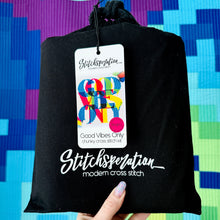 Load image into Gallery viewer, Black drawstring bag with 'Stitchoperation' branding and colorful tag against a multicolored geometric background.
